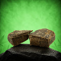 Canapuff Dry Sift Hash, zwei Stücke dunkles gepresstes Hash auf schwarzem Stein
